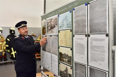 Ortswehrleiter Marcel Philipp zeigt den historischen Überblick über die Wehr, der so zum ersten Mal präsentiert wurde.