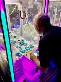 Ein Mann spielt an einem Spielautomaten, in dem mehrere Flaschen Desinfektionsmittel liegen. Der Betreiber eines britischen Ferienparks hat als Reaktion auf Hamsterkäufe wegen der Covid-19-Epidemie seine Spielautomaten mit Toilettenpapier und Desinfektionsmittel befüllt. Wo es sonst gilt, mit einem Greifarm Teddybären und andere Stofftiere aus dem Automaten zu angeln, sind jetzt die weißen Rollen und Flaschen mit Desinfektionsgel zu gewinnen. 