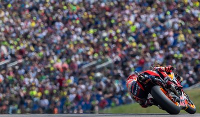 Marc Marquez  auf der Strecke vor einer Zuschauertribüne.