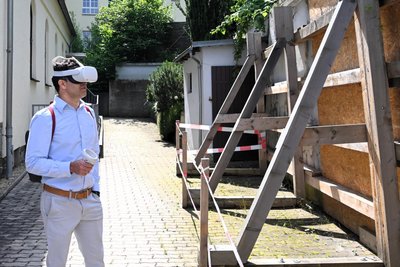 Die notgesicherte Synagogenmauer, hier mit Shai Goldberg, einem Nachfahren des Gemeindevorstehers Isidor Goldberg, beim Betrachten des Synagogenfilms in 3D. So könnte auch Giora Feidman die frühere Synagoge anschauen.