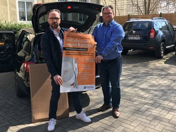 Detlef Knaack (l.), Vorstandsmitglied der DEHOGA Sachsen bei der Übergabe der Plakate an Axel Klein, Hauptgeschäftsführer der DEHOGA Sachsen in Dresden. 
