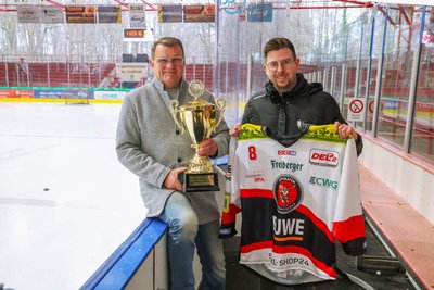 Vorfreude auf den Retro-Day am Freitag: Der ehemalige Kapitän Stefan Steinbock mit Meisterpokal und Eispiraten-Pressesprecher Aaron Frieß mit extra angefertigten Trikots.