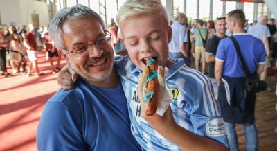 Paul Höhne und sein Opa Steffen Tröger probieren die neue Stadionwurst des Chemnitzer FC aus - samt himmelblauem Senf.