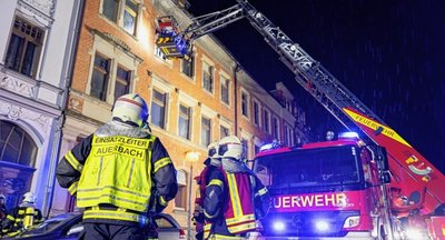 Mitglieder der Freiwilligen Feuerwehr Auerbach retten aus der zweiten Etage eine 65-jährige Bewohnerin mit der großen Drehleiter. Ein Stockwerk darunter holten sie einen 20-Jährigen aus der Wohnung. 