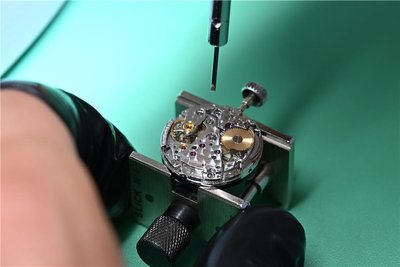 Das Uhrwerk einer Luxusuhr auf einem Werkhalter. Vor dem Verkauf werden die Uhren geprüft und gereinigt.