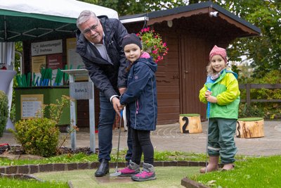 Sorina (6) und Marlene (4) beim ersten Abschlag, assistiert von Oberbürgermeister Rolf Schmidt.