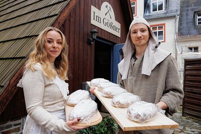 Stollenmädchen Marta Zimmermann und Verkaufsleiter Martin Seidler vom Unternehmen Annaberger Backwaren mit den Stollen, die ins Besucherbergwerk "Im Gößner" gebracht wurden. 