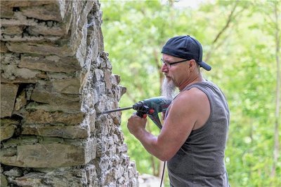 Die Pfad-Finder Buchholz richten die Ruine der einstigen Gottesackerkapelle nahe der B 101 wieder her. Im Bild: Falk Lorenz bereitet das Verfugen vor.