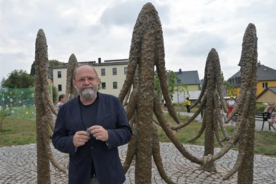 Alexander Ochs, Kurator des Purple Path, vor dem Kunstwerk „Include me out“ von Friedrich Kunath in Thalheim.