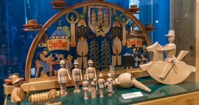 In einer Vitrine im Seiffener Spielzeugmuseum sind mehrere Figuren aus Naturholz zu sehen, die von Max Schanz entworfen wurden. 