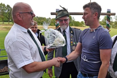 Vorsitzender Erik Wildfeuer (l.) beglückwünscht den Sieger von 2024, Enrico Schulze, ein Jahr später ist der Vorsitzende selbst der Sieger. In der Mitte Bernd Kleinichen.