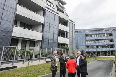 Sachsens Regionalentwicklungsminister Thomas Schmidt (zweiter von rechts) und NRW-Bauministerin Ina Scharrenbach (von hinten) im Gespräch mit den Fasa-Vorständen Ullrich Hintzen (links) und Gerald Lesch (zweiter von links) vor einem Solarthermie-Haus in Chemnitz. 