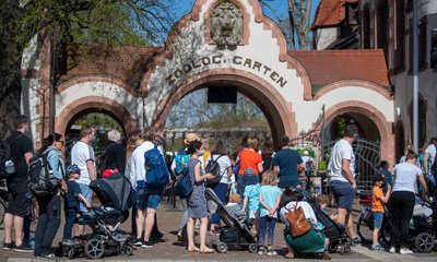 Besucher stehen vor dem Tor zum Zoo Leipzig.