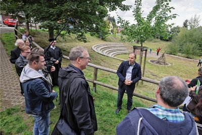 Auf dem Gelände des 2013 durch die Flut zerstörten Sportplatzes ist ein Amphitheater entstanden. In der Bildmitte Ortsvorsteher Lutz Weißpflug bei seinem Vortrag vor der Kommission. 