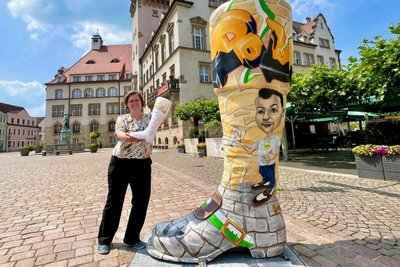 Kulturamtschefin Christiane Böttger mit dem Turmstiefel vor dem Döbelner Rathaus.