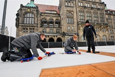 Vom 3. bis 26. Februar kann auf dem Chemnitzer Neumarkt Schlittschuh gefahren werden. Der Aufbau der Kunsteisbahn hat in dieser Woche begonnen. Im Bild: Marcel Sonntag, Marco Hartig und Philipp Schüppel (v. l.) 
