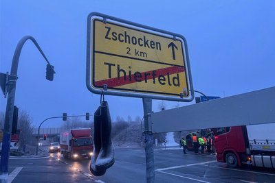 Neben der Proteststelle an der A-72-Anschlussstelle Aue-Hartenstein: Gummistiefel hängen an einem Ortsausgangsschild.