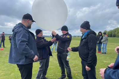 Lukas Michael (2. v. rechts) und Andreas Trommer (2. von links) bereiten den Ballon für den Start auf dem Sportplatz in Satzung vor. Andere Amateurfunker helfen dabei.