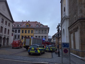 Fünf Feuerwehrfahrzeuge und zwei Polizeiautos rückten zum Einsatz in der Buttermarktgasse in Freiberg aus. Ein Großteil der Fahrzeuge stand auf dem Buttermarktgasse mit Nikolaikirche und Theater.