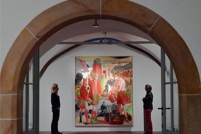 Besucherinnen betrachten das Bild "Wehr" des Malers Neo Rauch in der Sonderausstellung "Das Wehr" in der Gewölbehalle im Nordflügel der Hei-decksburg. 
