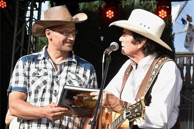 Mit einem großen Fest wurde am Samstag in Zwota das Jubiläum 20 Jahre Landbäckerei Behrendt gefeiert. Im Foto: Umjubelter Stargast war die Country-Legende Tom Astor, der den Inhaber Frank Behrendt (links) mit einem Buch über sein 50-jähriges Bühnenleben überraschte.