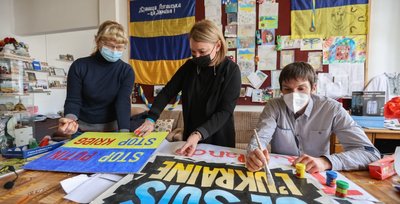 Olka Dreyer, Veronika Smalko und Yehor Zheliazkov (von links) bereiten Plakate für eine Kundgebung am Samstag um 14 Uhr am Roten Turm vor. Auf dieser wollen sie zur Solidarität mit ihrem Heimatland Ukraine aufrufen. 