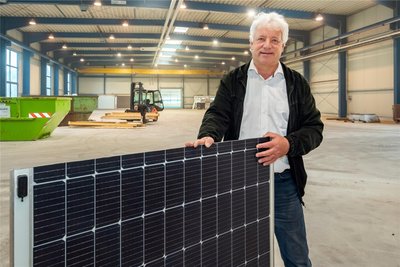 Geschäftsführer Torsten Enders zeigt im ehemaligen Glaswerk ein Ansichtsmuster eines innovativen Solarpanels.