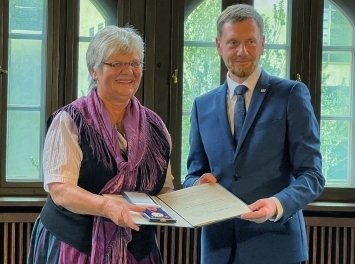 Ministerpräsident Michael Kretschmer überreicht Jutta Staudt den Bundesverdienstorden. 