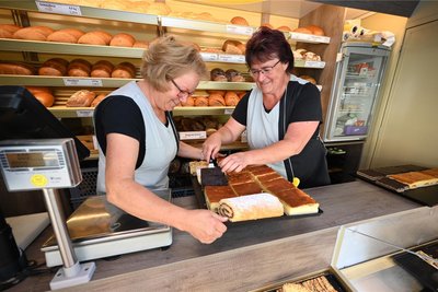 Tina Wolf (rechts) ordnet mit Sylke Böhme die Bäcker-Ware im mobilen Verkaufstresen der Bäckerei Schramm aus Dorfchemnitz ein.