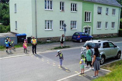 Sicherer Schulweg: Bürgerpolizist Uwe Frank übt mit Klingenthaler Schulanfängern. In der Dürrenbachstraße lernen die Kinder, wie sie die Straßen auch hinter parkenden Fahrzeugen sicher überqueren können.
