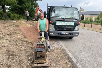 Andreas Günther (vorn) von der Lichtenauer Firma Steinbach & Richter GbR bei Bauarbeiten am Außengelände des Jugendtreffs.