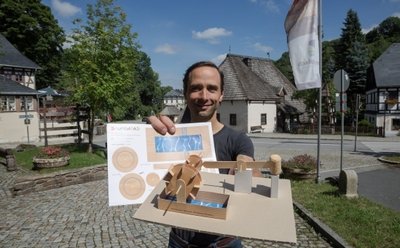 Sebastian Guthke mit dem Bastelbogen, mit dem die Kinder ihr eigenes kleines Hammerwerk bauen können.
