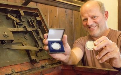 Jörg Bräuer, der amtierende Leiter der städtischen Museen, mit der Silbermünze, die es zum Jubiläum gibt.