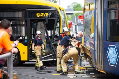 Einsatzkräfte sichern Unfallstelle nach Zusammenstoß von Tram und Bus.