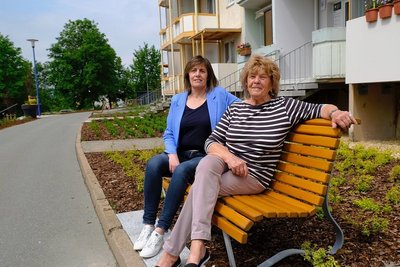 Carmen Brückner von der Woba und Mieterin Regina Fehlhauer auf einer der neuen Bänke an der Andreas-Schubert-Straße. 
