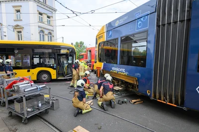 Feuerwehr hebt entgleiste Straßenbahn nach Unfall wieder ins Gleis.