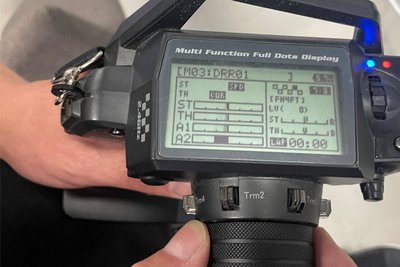 Per Fernbedienung lassen sich diverse Parameter einstellen, etwa die Lenkung (ST für Steering) oder die Beschleunigung (TH für Throttle).