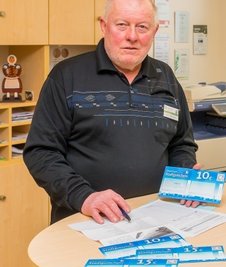 Touristinfo-Mitarbeiter Klaus-Dieter Erber zeigt die Olbernhauer Stadtgutscheine. 