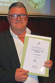 AC-Chef Mario Uhlig zeigt die Ehrenurkunde des Landessportbundes.