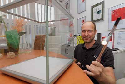 Geschäftsführer Bernd Schreiber mit einem Bestandteil des mehrfach ausgezeichneten Vitrinensystems Quickmodul und einem preisgekrönten LED-Spot.