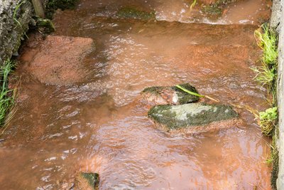 Das Wasser des Dorfbaches im erzgebirgischen Ortsteil Adorf hatte am Samstag eine braun-rötliche Färbung.