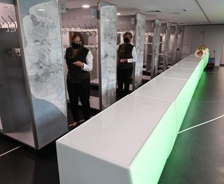 Die Garderobe mit dem grün beleuchteten Tresen befindet sich im hinteren Teil des Foyers im Erdgeschoss.