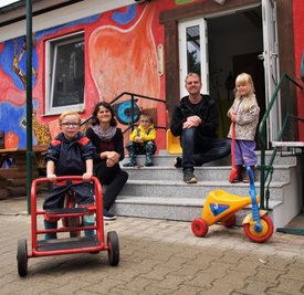 Maxim, Kitaleiterin Mareike Schlösser, Emil, der stellvertretende Kitaleiter Michael Kapps und Hermine (v.l.n.r) auf den neuen Treppenstufen im Eingangsbereich der Einrichtung.