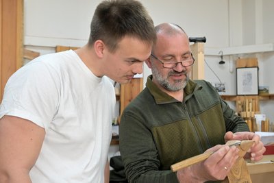 Holzbildhauer Lars Neubert (rechts) erklärt Franz Bräuninger, wie man das Schnitzmesser richtig ansetzt.