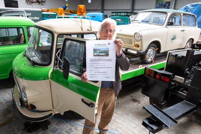 Mit dem Plakat fürs Oldtimertreffen in der Hand: Thomas Titze lebt seine Wartburg-Leidenschaft – vom IFA F9 bis zum 1.3 steht bei ihm nahezu die komplette Modellgeschichte.