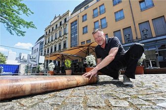 3D-Kunstwerk vom Zwickauer Kornmarkt abgebaut - Haustechniker Alexander Dietzsch rollt das 3D-Bild von Manfred Stader vor dem „First Inn“-Hotel ein.