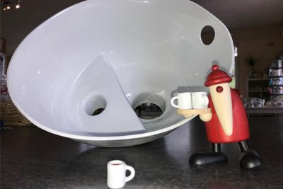 Die Holzfigur von Björn Köhler aus Eppendorf kredenzt Glühweinbecher aus Freiberger Porzellan. Im Hintergrund ein Trenn-Einsatz für Campingtoiletten, der ebenfalls an der Zuger Straße hergestellt wird.