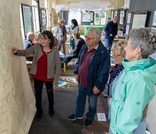 Petra Gronem-Schlosser (links) führt Besucher durch die Ausstellung, die Pfingsten in der Alten Stickerei Grünbach gezeigt wurde. 