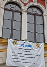 Mit einem Plakat wird an das 30-jährige Jubiläum erinnert.