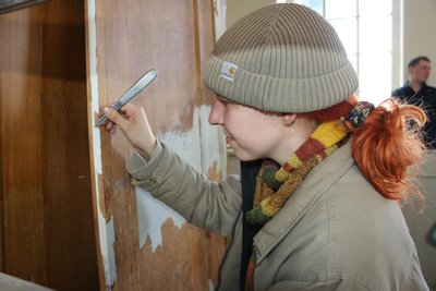 Emily Nordmann entfernt vorsichtig die alte Farbe von der Orgel.
